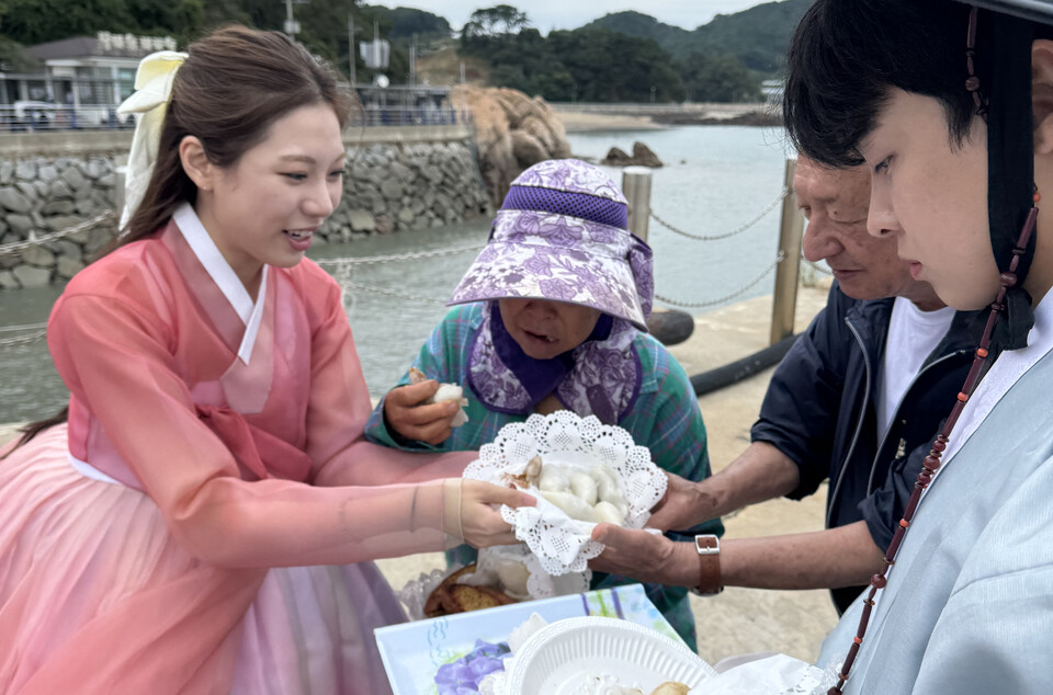 여행 참가자들이 섬 어르신들께 직접 만든 송편과 간식을 나눠드리고 있다./사진=인천항만공사