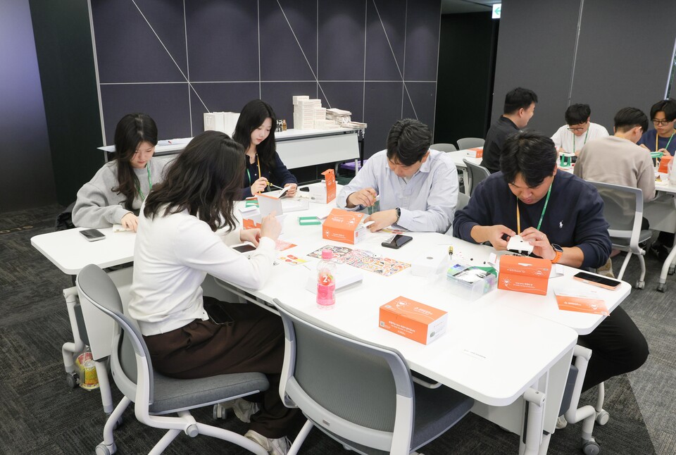 태양광 랜턴 만들기 봉사활동에 참여한 현대엘리베이터 임직원들이 점심시간을 이용해 제품을 조립하고 있다./현대엘리베이터 