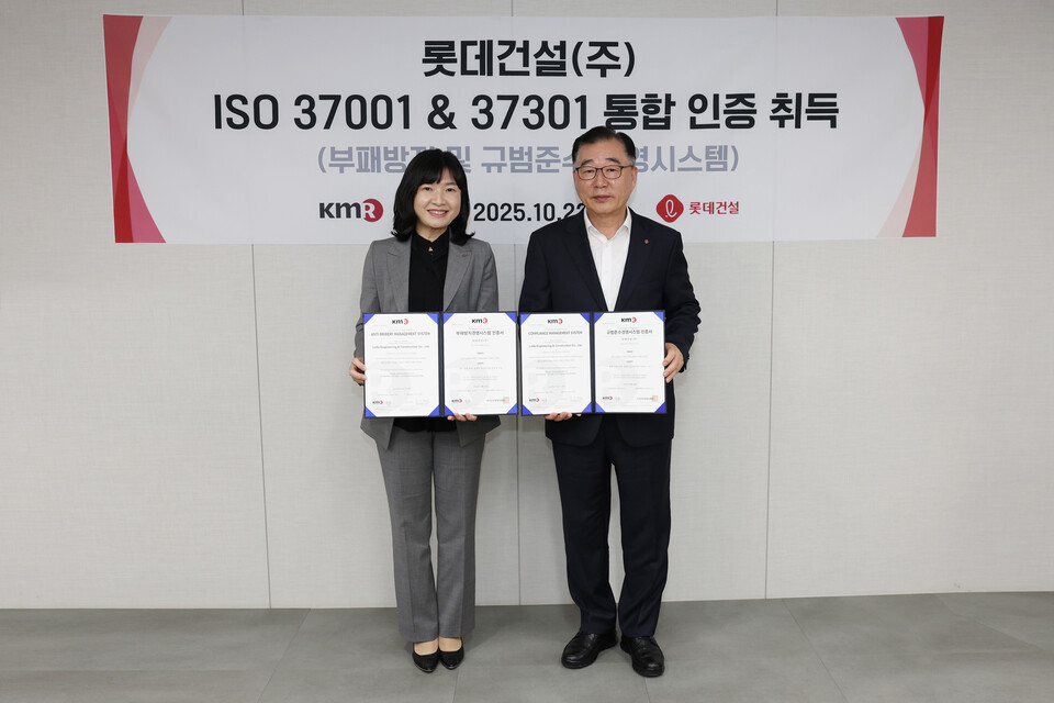 박현철 롯데건설 부회장(오른쪽)과 황은주 한국경영인증원 대표이사(왼쪽)가 ISO 통합인증 수여식에서 기념촬영을 하고 있다./롯데건설
