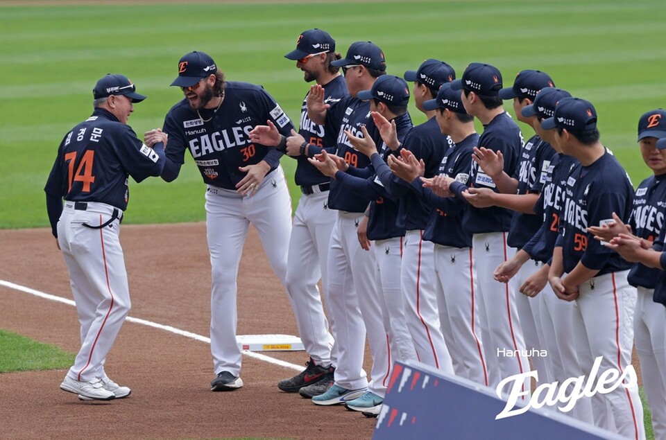 김경문 감독(왼쪽 첫 번째)과 폰세가 한국시리즈 직전 행사에서 손을 맞잡고 미소 짓고 있다. /한화 이글스 제공