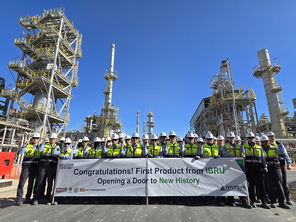 가솔린 생산을 축하하는 플래카드를 들고 이라크 바스라 정유공장 고도화설비 공사 현장 임직원들이 기념사진을 촬영하고 있다./현대건설
