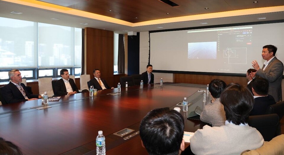 폴 르윈 해벅AI CEO(오른쪽 발표자)가 지난 28일 한화 임직원들에게 하와이 앞 바다에 대기 중인 해벅AI의 무인수상정을 한화오션 거제사업장에서 원격 통제하는 기술 시연을 선보이고 있다./한화시스템