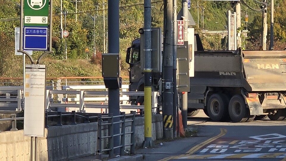 지난 11월 3일 오후, 용인시 수지구 고기동 고기초등학교 앞 도로. 인도조차 없는 왕복 2차로 도로에 차량이 줄 지어 지나갔다. 이곳을 하루 400여 대의 대형 덤프트럭이 통행할 것이라는 소식이 전해지자, 주민들의 불안은 곧 분노로 바뀌었다./ 김두일 기자