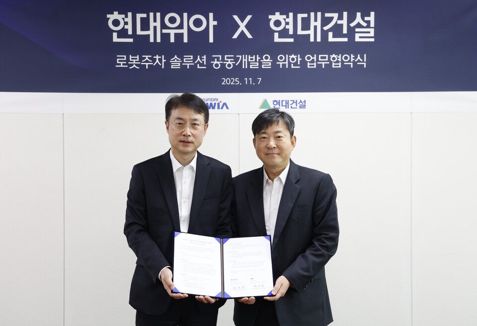 현대건설 기술연구원 김재영 원장(오른쪽)과 현대위아 모빌리티솔루션사업부 백익진 상무가 7일 경기도 의왕시 현대위아 의왕연구소에서 열린 ‘로봇 친화형 주차솔루션 공동개발을 위한 업무협약식’에서 기념 사진을 찍고 있다./현대건설