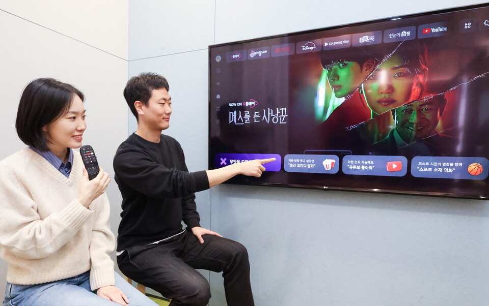 고객이 IPTV 전용 리모콘 '무엇을 도와드릴까요' 버튼을 누르고 리모컨에 음성 주문을 넣는 모습./LG유플러스