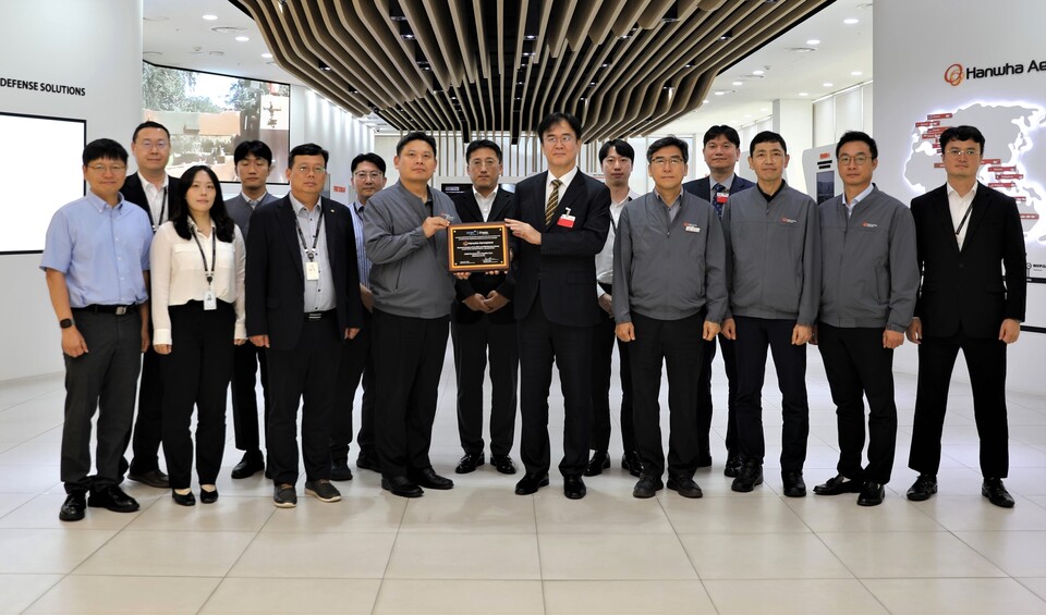 한화에어로스페이스 안홍규 임원(왼쪽 네 번째)과 정상욱 CMMI High Maturity 선임심사원(ITQC 대표)이 인증 후 기념 촬영을 하고 있다./한화에어로스페이스