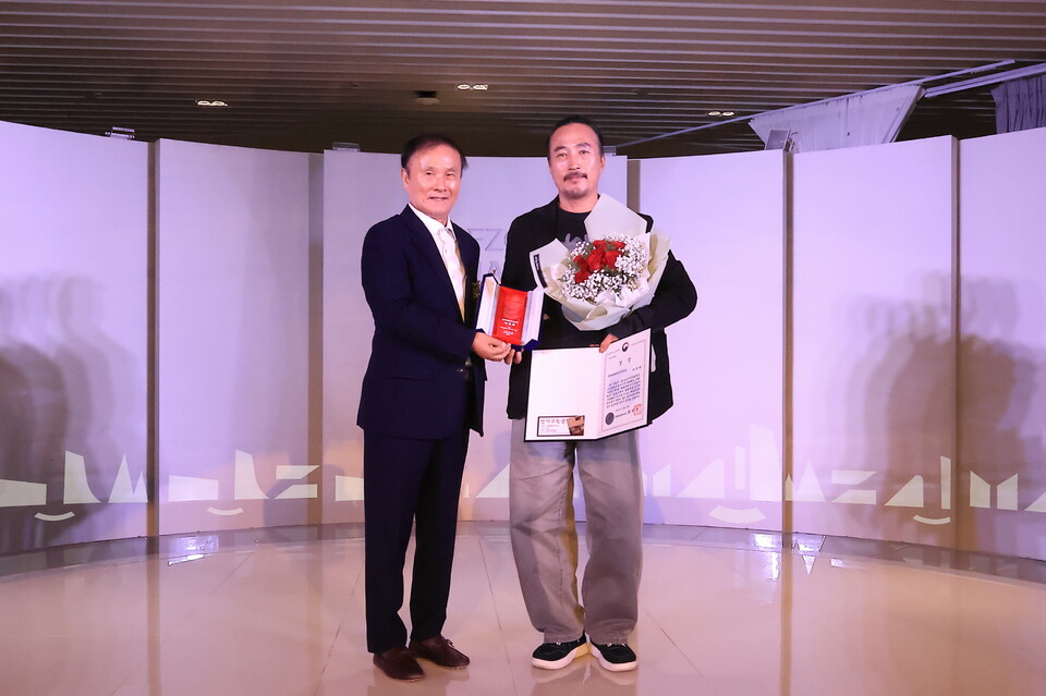 13일 골프존조이마루에서 열린 제5회 ‘철화분청사기 산업이 되다’ 시상식에서 김영찬 골프존문화재단 이사장(왼쪽)이 대상을 수상한 박연태 작가에게 상장과 트로피를 수여하고 기념촬영을 하고 있다. /골프존문화재단 제공