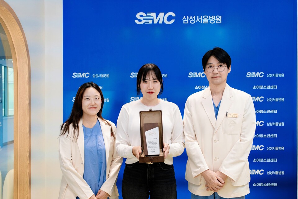 나주영 앳홈 미닉스 BO(가운데)가 삼성서울병원 소아청소년센터에서 진행된 기부금 전달식에 참여해 기념 촬영을 하고 있다./앳홈