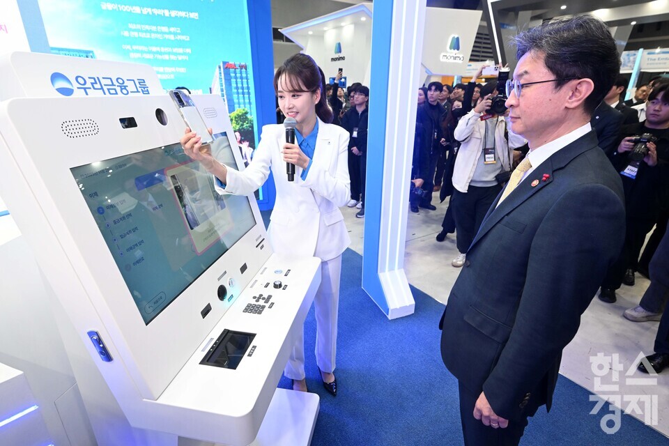 이억원 금융위원장이 26일 서울 서초구 aT센터에서 열린 코리아핀테크위크 2025 우리금융그룹 부스에서 금융사기를 예방하는 인공지능(AI) 키오스크를 체험하고 있다./ 이호형 기자 leemario@sporbiz.co.kr 2025.11.26